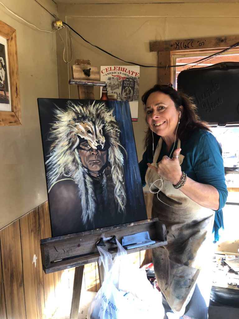Artist Terry Glad Flores with her finished painting of Zahn McClarnon